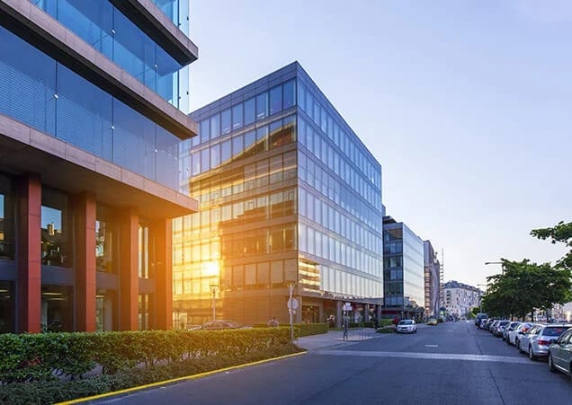 A modern commercial property with large glass windows and a well-maintained exterior, set against a clear blue sky.