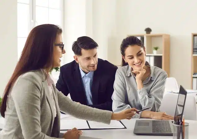 comprehensive-private-client-ins A person reviewing an insurance document with a pen in hand, alongside a laptop and coffee cup on a wooden desk, representing comprehensive private client insurance services.