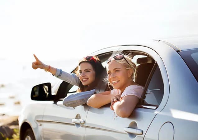 drive-with-confidence A confident driver holding a steering wheel with a scenic road view ahead, promoting safe and secure driving.