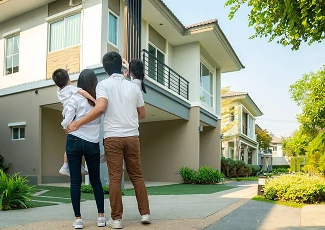 ensure-your-property A person holding a small model house in their hands, symbolizing property protection and home insurance.