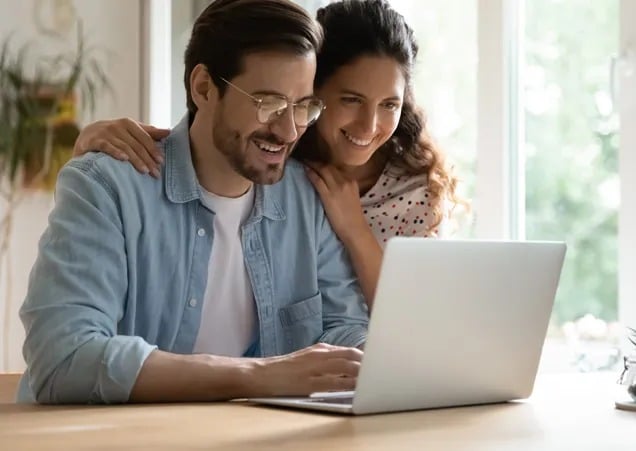 personalised-insurance-plans A family of three—father, mother, and young daughter—sits together at a table, smiling while reviewing documents with an insurance agent.